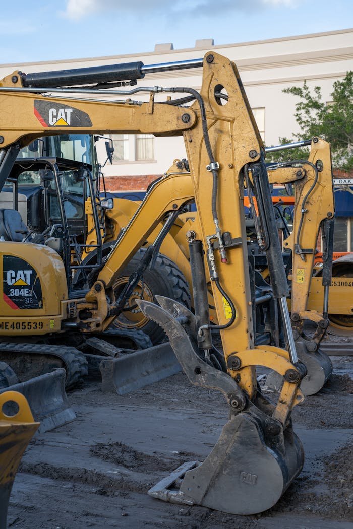 The Art of Drawing Readers In: Your attractive post title goes here Yellow excavators at a construction site with machinery and equipment in the foreground.