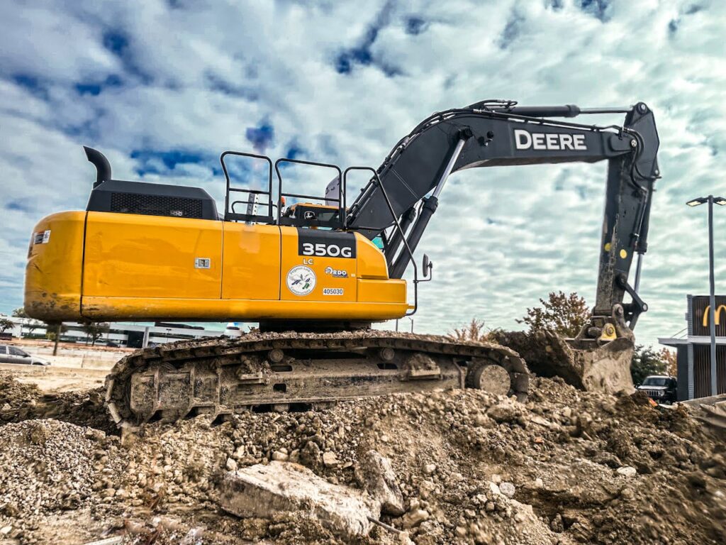 Yellow excavator at work in an urban construction site, showcasing industrial machinery.